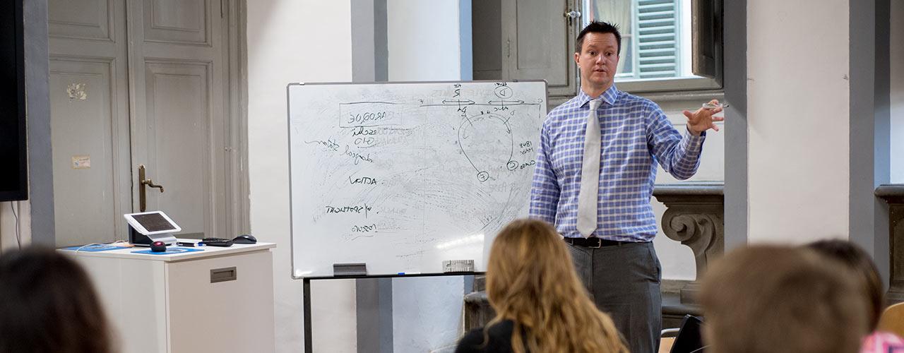 Male history professor using whiteboard to illustrate concepts to the class